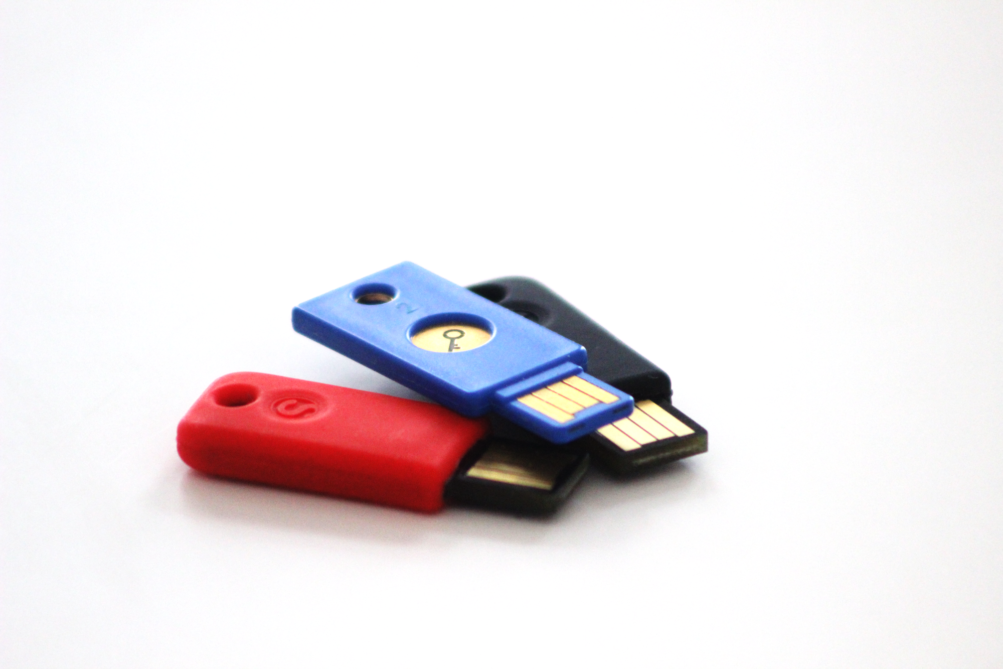 Roter schwarzer und blauer USB-Stick vor weißem Hintergrund